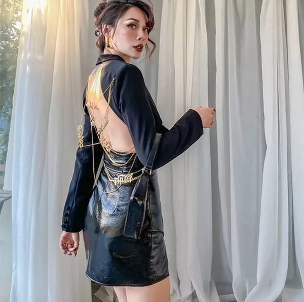 Blazer feminino estruturado com recorte profundo nas costas e correntes douradas decorativas, modelagem ajustada e tecido sofisticado