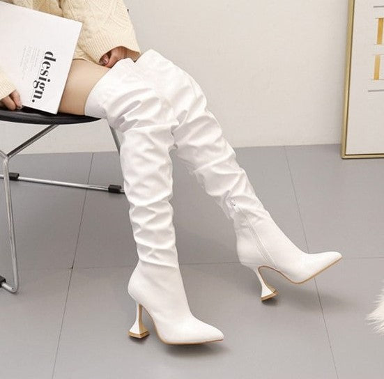 Bota feminina over the knee em couro sintético com acabamento plissado e salto taça alto, modelo acima do joelho.