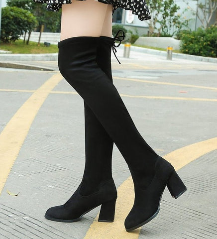 Bota feminina over the knee preta com tecido elástico e salto grosso médio, modelo ajustado e confortável para looks de inverno