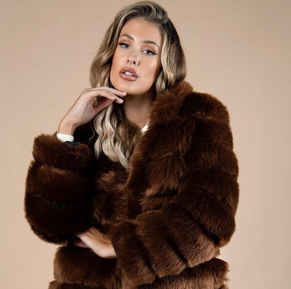 Casaco feminino de pelos sintéticos com gola volumosa, modelagem estruturada e acabamento sofisticado, ideal para o inverno