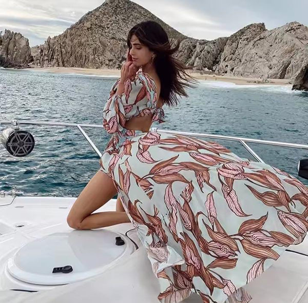 Vestido longo estampado com manga longa, decote V profundo e recorte na cintura, ideal para festas e casamentos