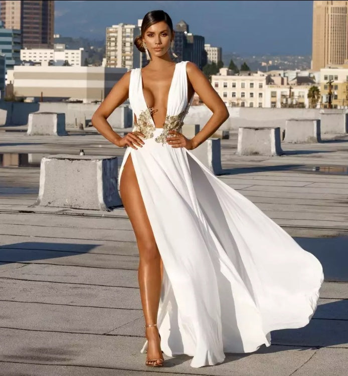 Vestido longo sem mangas com decote V profundo, fenda lateral e cintura bordada. Look elegante, sofisticado e glamouroso.