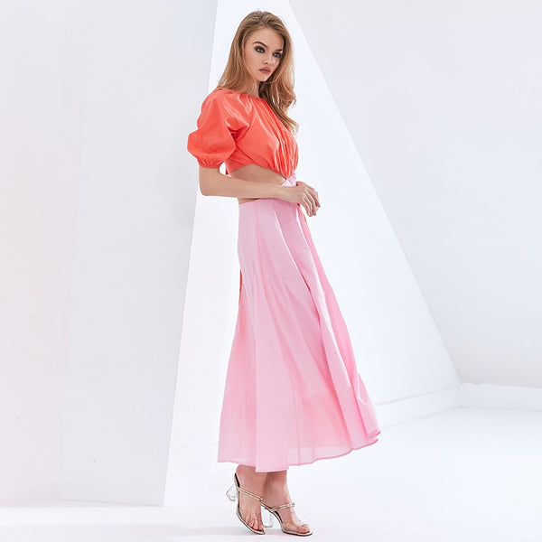 Vestido midi em chiffon com manga curta bufante, recorte na cintura e design em bloco de cor. Look leve, elegante e sofisticado.