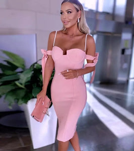 Vestido midi justo com alcinha, decote coração, detalhe em laços nos ombros e alças em strass. Look elegante, feminino e sofisticado.
