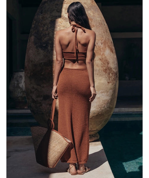 Vestido midi em malha canelada, com decote halter, recortes na cintura e costas abertas. Modelagem justa, elegante e confortável.
